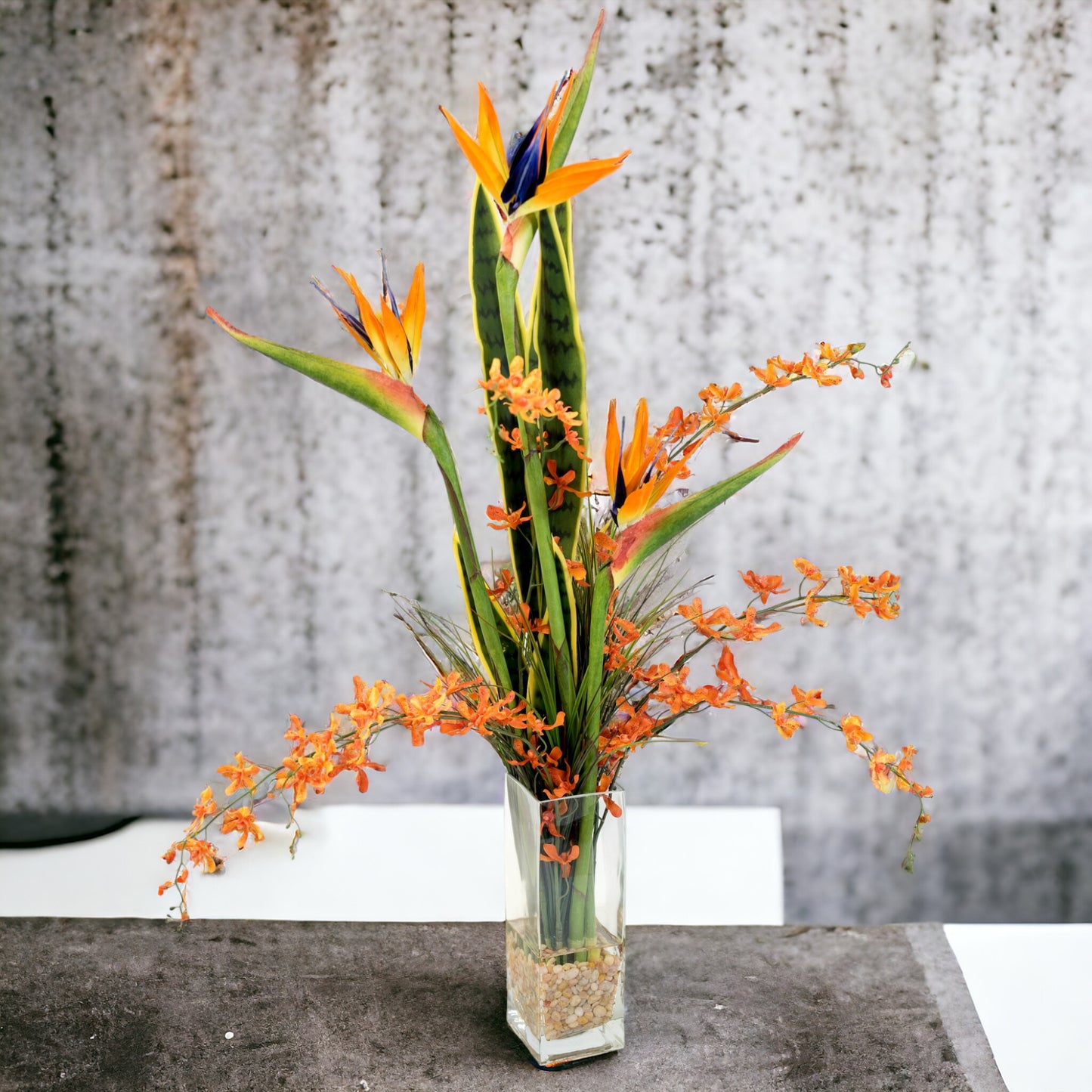 Tropical blend of Sansevieria and Bird of Paradise in glass with acrylic water look.