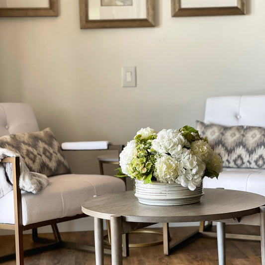 White hydrangea arrangement in a ceramic container.